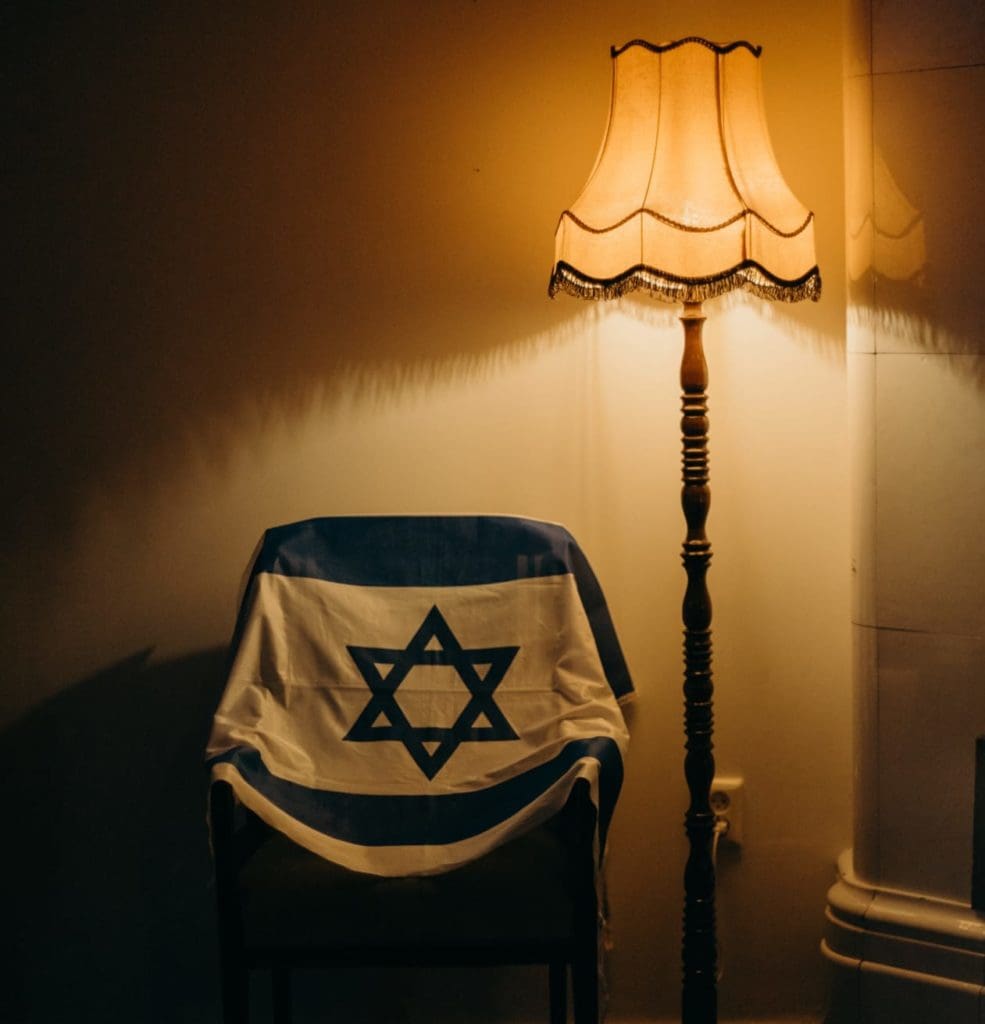 Bandeira israelense na cadeira e luzes fracas, uma memória de um ente querido, herança e sucessão em isreal é uma faca de dois gumes