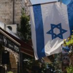 una bandiera appesa a un edificio in una città in Israele legge sulla successione e legge sulla successione in Israele fare testamento legge sulla successione in Israele eredità in Israele
